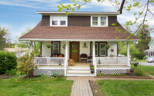 The porch of this Chester home features a porch swing and plenty of wicker furniture for outdoor entertaining. Photo Credit: Hometown Vision