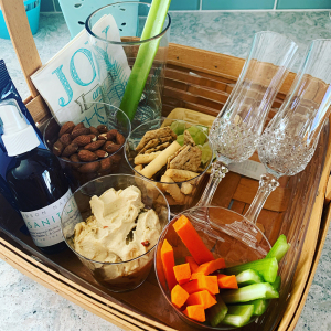 Social distancing basket prep includes Hudson Naturals Hand Sanitizer. 2 glasses for Prosecco and one glass with a celery for a Bloody Mary. Take drink orders before guests arrive if you are entertaining outdoors.