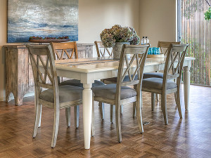 A close-up of a staged dining room featuring cool wood tones and a reclaimed wood server in similar cool tones. Staging: Claudia Jacobs Designs. Photo Credit: Steve Belner, Photovisions.